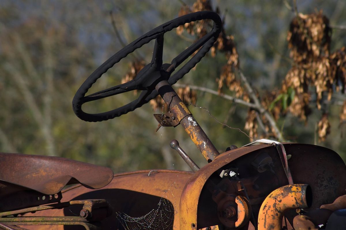 Volanul și coloana de direcție ale unui tractor vechi, ruginit